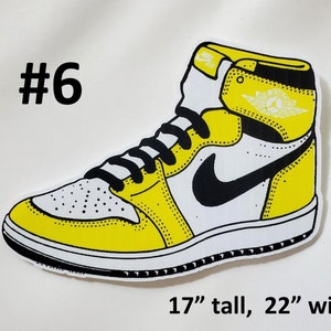 May include: Yellow and white basketball shoe with a black swoosh logo. The shoe is 17 inches tall and 22 inches wide. #6