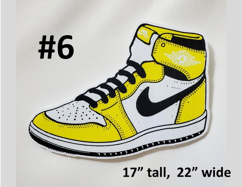 May include: Yellow and white basketball shoe with a black swoosh logo. The shoe is 17 inches tall and 22 inches wide. #6