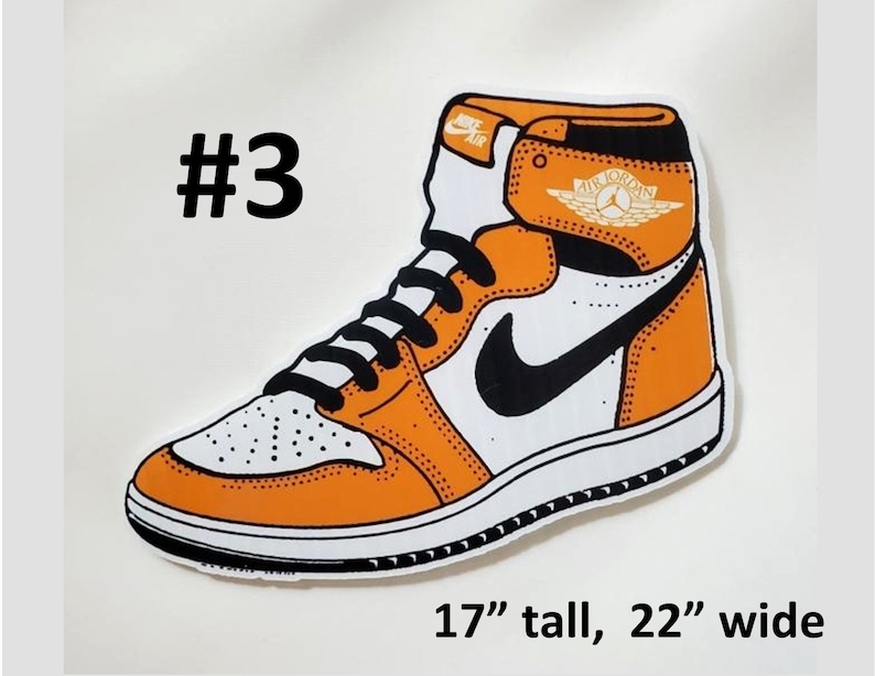 May include: A cartoon illustration of an orange and white basketball shoe with a black swoosh and a gold "Air Jordan" logo. The shoe is 17 inches tall and 22 inches wide.