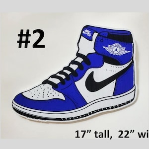 May include: Blue and white Air Jordan sneaker with a black swoosh and the text "Air Jordan" on the side. The sneaker is 17 inches tall and 22 inches wide.