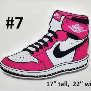 May include: A pink and white Air Jordan sneaker with a black swoosh and the text "AIR JORDAN" on the side. The sneaker is 17 inches tall and 22 inches wide.