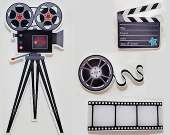 May include: A black and white film camera with a tripod, a film reel, a film strip, and a clapperboard with the words "Title", "Actors", "Date", and "Time of scene".
