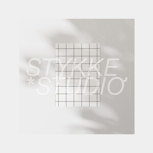 K&ouml;nnte beinhalten: Ein wei&szlig;es Logo auf hellgrauem Hintergrund mit einem Gittermuster. Das Logo lautet "STYKKE *STUDIO"