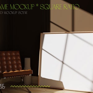 Puede incluir: Una silla de cuero marrón con un marco de madera se encuentra en una habitación con un gran marco blanco cuadrado en la pared. El marco es de madera y tiene un acabado de madera clara. La habitación está decorada en un estilo moderno con paredes oscuras y un suelo de madera. El marco está en el centro de la imagen y es el foco principal. La silla está en primer plano y está ligeramente desenfocada. El texto "FRAME MOCKUP * SQUARE RATIO" y "STYLED MOCKUP SCENE" es visible en la parte superior de la imagen.