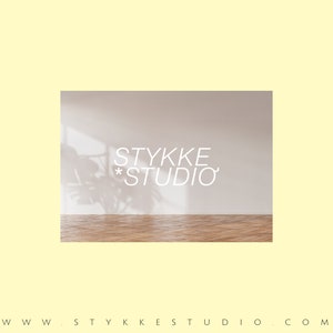 Peut inclure: Un logo de studio de design d'int&eacute;rieur minimaliste avec le texte "STYKKE *STUDIO*" en blanc sur un mur beige clair avec l'ombre d'une plante sur le mur. Le sol est en bois brun clair.