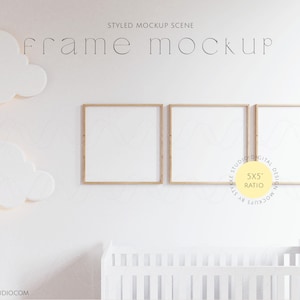 Puede incluir: Tres marcos de fotos de madera con paspartús blancos, colgados en una pared blanca con una cuna blanca en primer plano. Los marcos están dispuestos en fila, con el marco del medio ligeramente más alto que los otros dos. La pared está decorada con dos nubes blancas. El texto "frame mockup" está escrito en negro sobre los marcos. El texto "5x5 ratio" está escrito en amarillo dentro de un círculo debajo de los marcos.