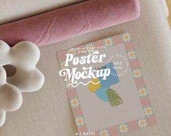 Op de afbeelding: Een gestileerde poster mockup met de tekst "Poster Mockup" in een neutrale setting. De poster heeft een roze rand met bloemaccenten en abstracte vormen. Een roze bolsterkussen en een wit bloemvormig kussen staan ook in de afbeelding.