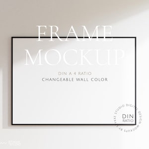 May include: A black frame mockup on a white wall. The frame is empty and has a DIN A4 ratio. The text "FRAME MOCKUP" is above the frame and the text "DIN A4 RATIO" and "CHANGEABLE WALL COLOR" are below the frame.