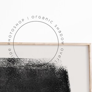 Puede incluir: Una impresi&oacute;n de arte abstracto en blanco y negro en un marco de madera. La impresi&oacute;n presenta una gran forma negra con una superficie texturizada. El marco est&aacute; en una pared blanca con el texto "side PHOTOSHOP | organic SHADOW over" en un c&iacute;rculo.