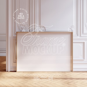 May include: A gold frame mockup with a white background. The frame is sitting on a wooden floor with a white wall and decorative molding in the background. The text "Frame Mockup" is written in white on the frame.