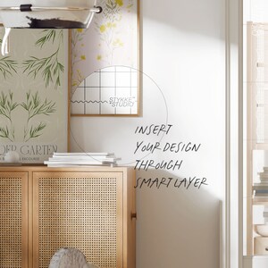 Puede incluir: Un mueble de madera clara con frente tejido y una pila de libros blancos. Dos estampados bot&aacute;nicos enmarcados cuelgan de la pared. El texto "INSERT YOUR DESIGN THROUGH SMART LAYER" est&aacute; escrito en la pared.