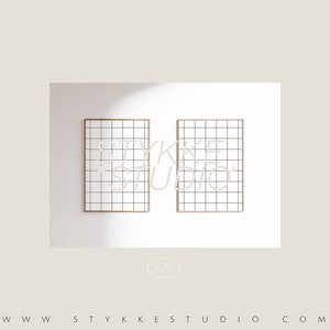 May include: Two framed prints with a grid pattern and the text "YKKE STUDIO" in a light beige color. The frames are a light brown color, and the background is white.