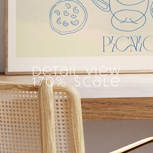 Puede incluir: Una impresi&oacute;n enmarcada con un fondo azul claro y un dibujo de l&iacute;nea azul de una cesta de picnic, una taza, un plato de comida y la palabra "PICNIC". El texto "Detail View 170% Scale" est&aacute; debajo de la imagen.