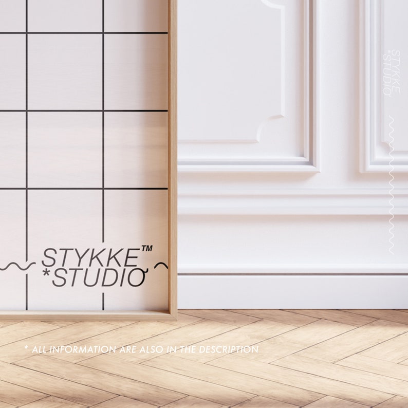 May include: A framed print with a black and white grid pattern and the text "STYKKE&trade; *STUDIO*" in black. The frame is made of wood and has a light brown finish. The print is sitting on a wooden floor with a herringbone pattern.
