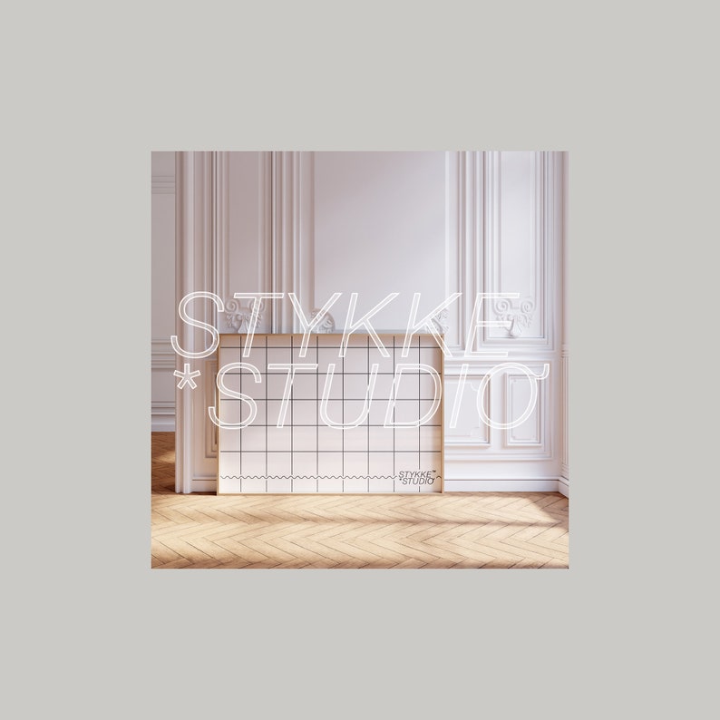 May include: A white gridded board with a gold frame, with the text "STYKKE STUDIO" in white outlined letters. The board is in a room with white walls and white trim.