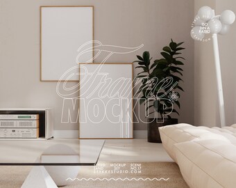 May include: A living room interior design mockup with two framed posters, a houseplant, a couch, and a glass coffee table. The posters are blank and ready for your design.