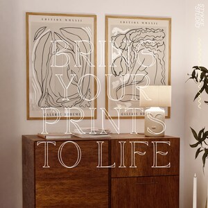 May include: Two framed black and white line art prints with the text "EDITION MMXVII" and "GALERIE BOHEME" on a wooden dresser with a white ceramic lamp. The text "BRING YOUR PRINTS TO LIFE" is superimposed on the image.