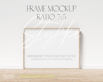 Puede incluir: Una escena de maqueta con un marco de madera clara y un fondo blanco. El marco está sobre un suelo de madera clara frente a una pared blanca. El texto "FRAME MOCKUP RATIO 7x5" está por encima del marco. El texto "MINIMALISTIC STYLED MOCKUP SCENE * Displayed artwork & fonts not included" está debajo del marco.