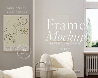 Op de afbeelding: Een gestileerde mockup van een gouden lijst met een botanische illustratieprint erin. De lijst hangt aan een lichtgrijze muur met een witte fauteuil en een bijzettafel ervoor. De print toont een gestileerde tekening van een tak met bladeren in tinten groen op een lichtbeige achtergrond. De tekst "WILDER GARTEN" is zichtbaar onderaan de print.