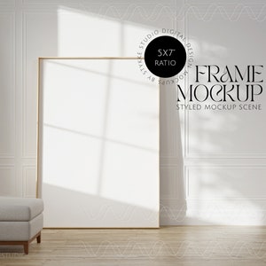 Pu&ograve; includere: Un mockup di cornice dorata in una stanza bianca con un divano grigio chiaro. La cornice misura 12,7 x 17,8 cm e il testo "FRAME MOCKUP" &egrave; visibile nell'immagine.