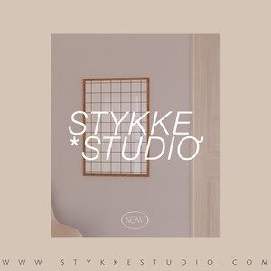 Puede incluir: Una pieza de arte enmarcada con una cuadr&iacute;cula y un marco de madera cuelga de una pared gris claro. El texto "STYKKE STUDIO" se muestra en blanco, junto con la palabra "NEW" en un c&iacute;rculo. La direcci&oacute;n del sitio web est&aacute; en la parte inferior.