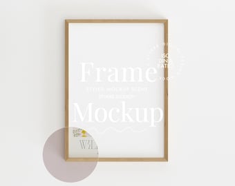 Pode incluir: Uma maquete de moldura de madeira clara com fundo branco. A moldura está em uma parede branca com um círculo rosa claro atrás. O texto "Frame Mockup" está escrito em branco na moldura.