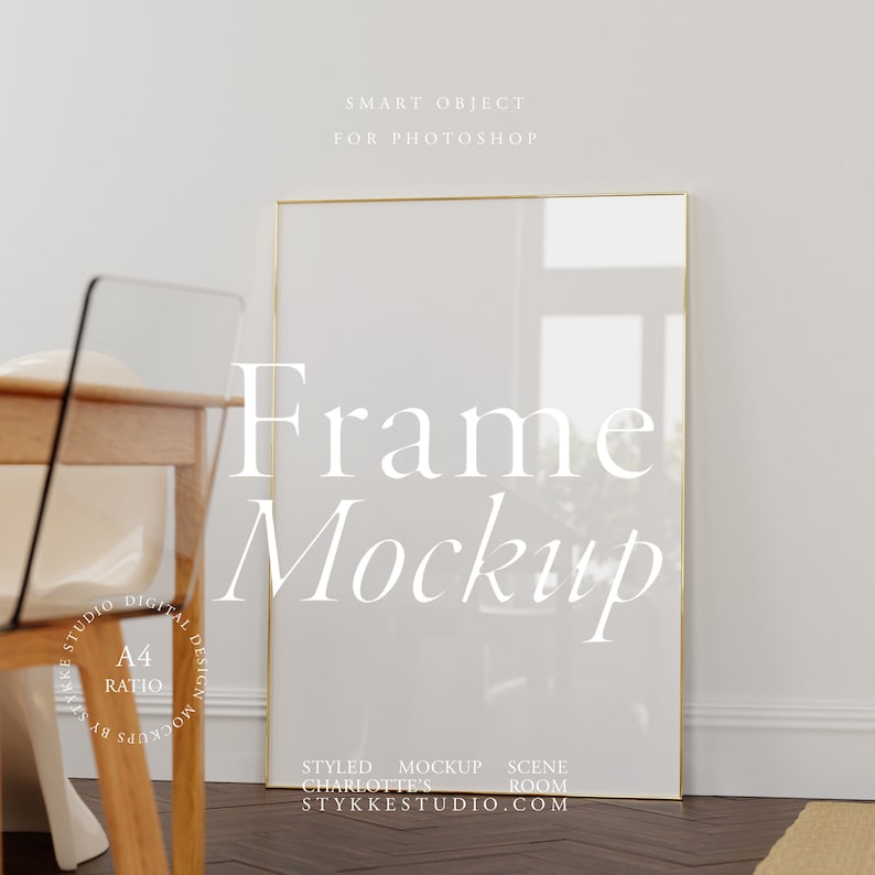 Tall thin golden frame standing on wooden floor leaning to a wall. In front of the frame is a wooden dining table with chairs