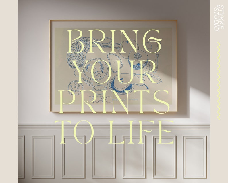 May include: A framed print featuring a blue and white abstract design. The print is displayed on a white wall with white panelling. The text "BRING YOUR PRINTS TO LIFE" is written in yellow lettering below the print.