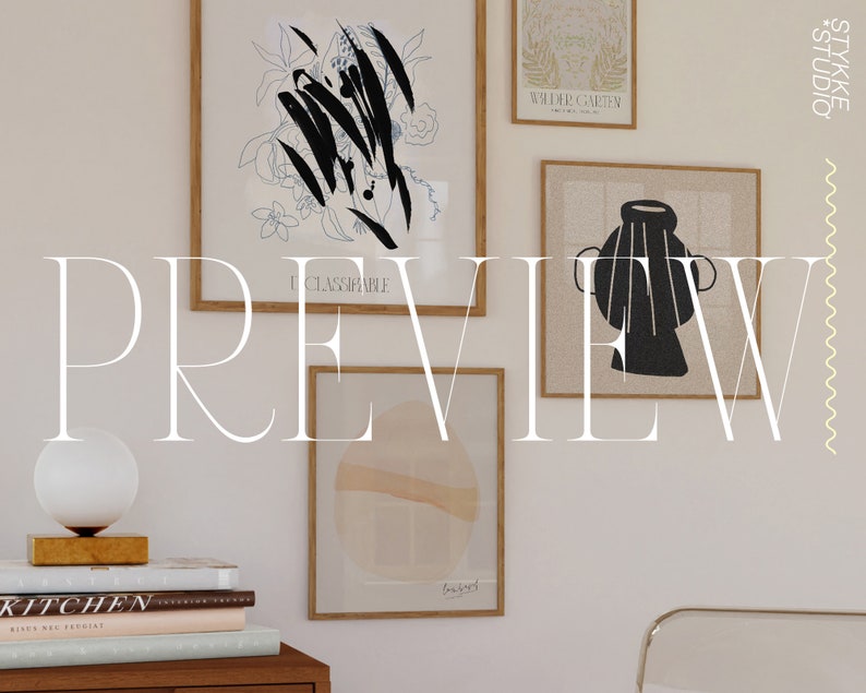 May include: A white wall with a collection of framed art prints. The prints feature abstract designs in black and white, a vase, and a floral motif. The wall is decorated with a white lamp and a stack of books.