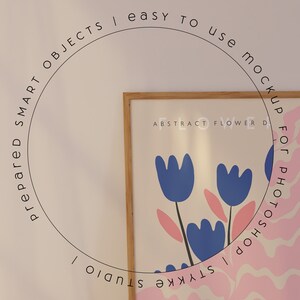 Puede incluir: Una impresi&oacute;n enmarcada con un dise&ntilde;o abstracto de flores rosa y blanco. La impresi&oacute;n est&aacute; en un marco de madera y tiene el texto "ABSTRACT FLOWER DESIGN" en la parte superior. El texto "STYKKE STUDIO" est&aacute; en el lado derecho de la impresi&oacute;n. El texto "prepared SMART OBJECTS | easy to use mock up for PHOTOSHOP" est&aacute; en un c&iacute;rculo alrededor de la impresi&oacute;n.