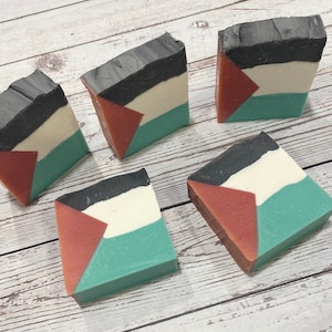 May include: Five handmade soap bars with a geometric design. The bars are black, white, red, and green.