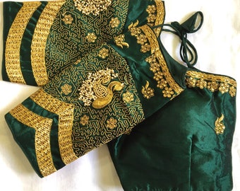 May include: A dark green silk blouse with gold embroidery and embellishments. The blouse has a round neckline and a back tie closure.