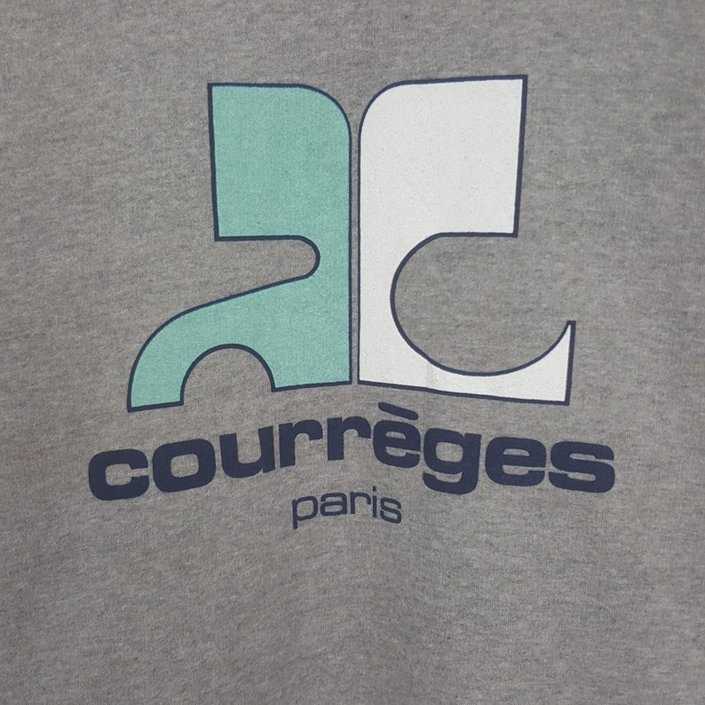 Pode incluir: Camisola cinzenta com um design gr&aacute;fico turquesa e branco. A palavra "courr&egrave;ges" est&aacute; impressa em azul marinho, com "paris" por baixo. A camisola tem gola redonda e mangas compridas.