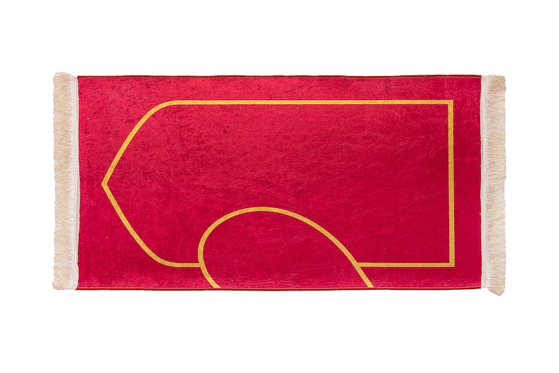 May include: A red prayer rug with a gold geometric design and cream-colored fringe. The rug features a central rectangular shape with a curved design, suitable for prayer and meditation.