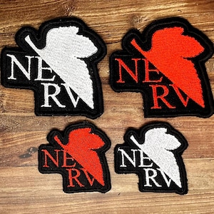 May include: Four embroidered patches featuring the NERV logo. Two patches are larger and two are smaller. Each patch has a black background with the text NERV in white or red, accompanied by a stylized leaf-like graphic in the same color.