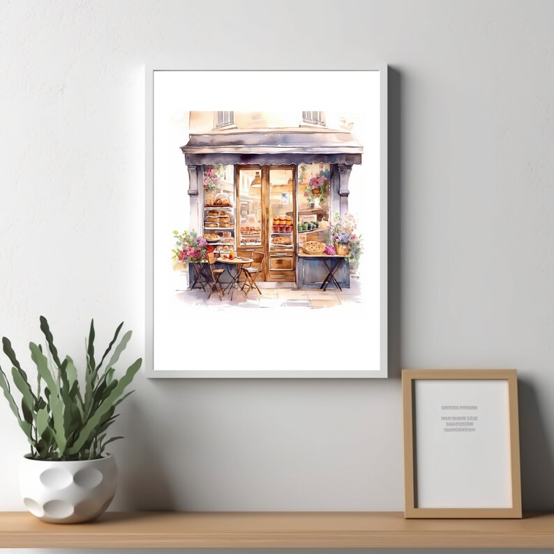 May include: Watercolor painting of a small bakery storefront with a brown awning, a glass door, and two tables with chairs outside. The bakery window displays a variety of baked goods, including bread, pastries, and pies.
