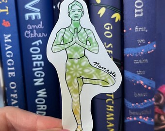 May include: A sticker of a person in a yoga pose with a green and yellow mandala pattern. The sticker is on a white background and has the word "Namaste" written on it.