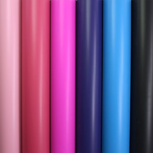 Könnte beinhalten: Nahaufnahme von sechs Rollen Vinyl-Klebepapier in verschiedenen Farben, darunter Pink, Magenta, Dunkelblau, Hellblau und Schwarz.