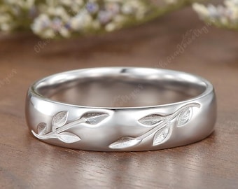 Könnte beinhalten: Ein silberfarbener Ring mit Blattmuster. Der Ring hat eine polierte Oberfläche und eine Bandbreite von etwa 4 mm. Das Blattmuster ist um die Außenseite des Rings geätzt und verleiht ihm eine natürliche Eleganz.