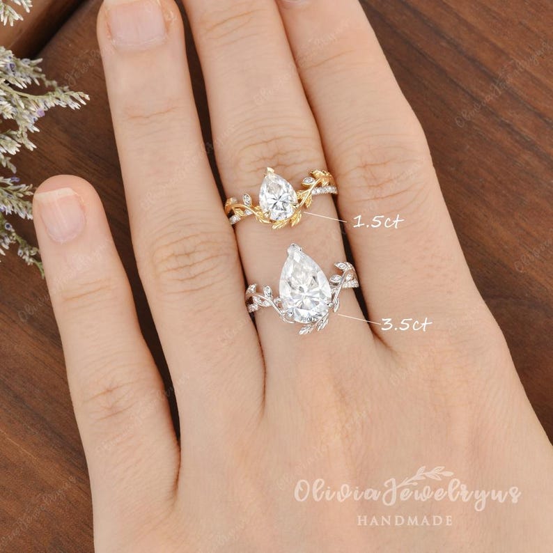May include: Two pear-shaped diamond engagement rings with delicate leaf and vine details. The ring on the left has a 1.5ct diamond, and the ring on the right has a 3.5ct diamond.  Olivia Jewelry by Us HANDMADE.