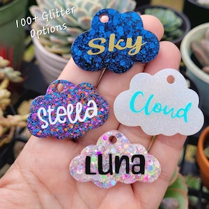May include: Four colorful cloud-shaped name tags with glitter. The names "Sky", "Stella", "Cloud", and "Luna" are written on the tags.