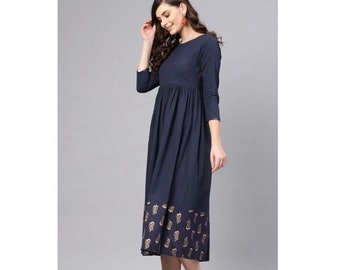 May include: A navy blue midi dress with a gold paisley print on the bottom hem. The dress has a round neckline and long sleeves.