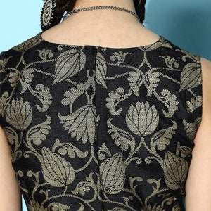 May include: Black sleeveless top with a gold floral pattern. The top has a back zipper closure.