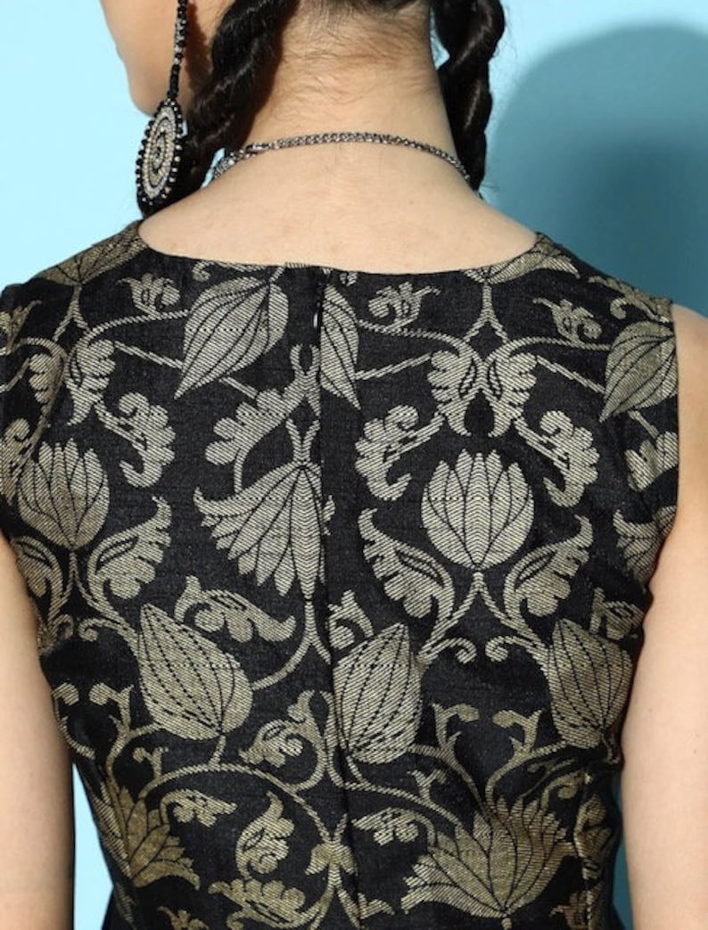 May include: Black sleeveless top with a gold floral pattern. The top has a back zipper closure.