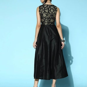 May include: A black sleeveless dress with a gold floral pattern on the bodice and a flowing skirt.