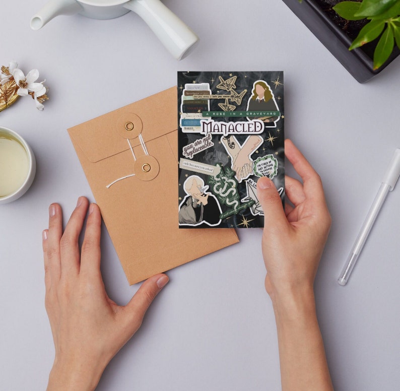 K&ouml;nnte beinhalten: Eine Karte mit schwarzem Hintergrund und verschiedenen Aufklebern. Die Aufkleber zeigen ein Paar, das sich an den H&auml;nden h&auml;lt, eine Schlange, ein Buch und ein Zitat, das lautet "Du bist nicht ersetzbar".