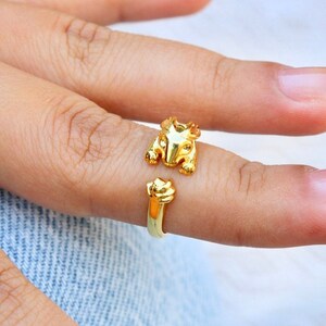 May include: Gold ring with a detailed animal design. The ring is open and adjustable.
