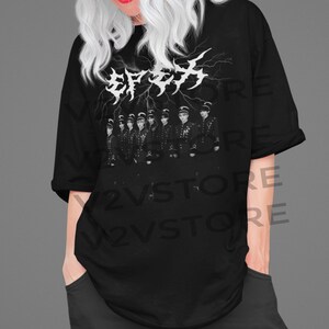 May include: Black t-shirt with a white graphic of a group of people in military uniforms. The graphic includes the text "Stray Kids" in white with lightning bolts behind it.