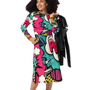 May include: A long-sleeved dress with a colorful pop art print featuring a comic book style design with the word "POW!" in a speech bubble. The dress is pink, yellow, blue, and black.