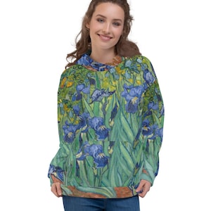 Puede incluir: Una sudadera con capucha verde y azul con un estampado de una pintura de flores de iris. La sudadera tiene una capucha con cordón y un bolsillo canguro.